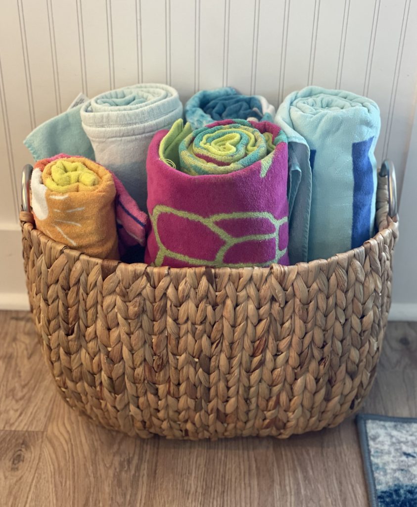 Basket of colorful beach towels for guests at a vacation rental, a practical extra for pool, beach, and waterfront stays.