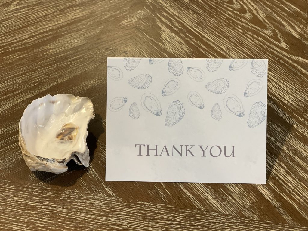 Vacation rental thank-you note with oyster shell accent, a simple welcome touch for guests.